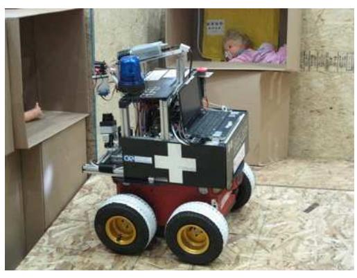 (a) Our Pioneer 3 AT-based robot *Robbie*.