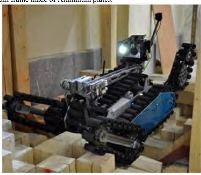 A pair of supplementary tracks under the main frame facilitates movement in uneven terrains