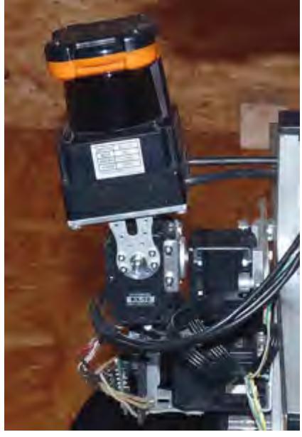 (a) The Hokuyo UTM-30LX laser range finder (LRF), mounted on a self-built rotation/tilt-unit. (b) Map generated from data of a rigidly coupled LRF. (c) Map generated from data of an adjusted LRF. Fig. 7: The gimbal-mounted Hokuyo UTM-30LX laser range finder (a) and the effect on the mapping: Map without (b) and with (c) adjustment. The map based on the data acquired by the adjusted LRF has more aligned walls and less artefacts.