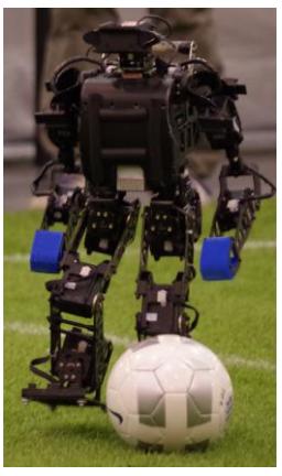 Fig. 1. Robot of ZJUDancer (a) kicking the ball (b) mechanical sketch