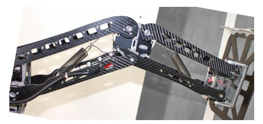 Mechanical details of Copedo: overload protection in the hip with preloaded spring (left); parallel leg kinematics with knee spring (right).