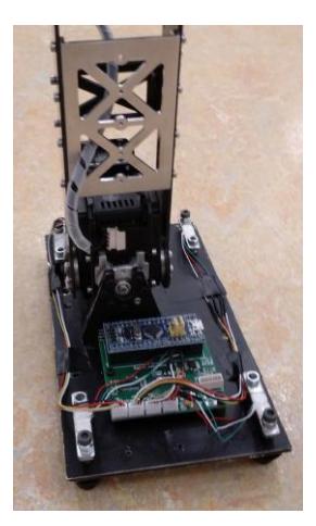Fig. 1a: The hardware implementation of the ForceFoot. In each of the four corners of the foot, a load cell sensor is mounted. The sensor data is collected and fed into the Dynamxel bus system by an STM32F103 with an external analog to digital converter.
