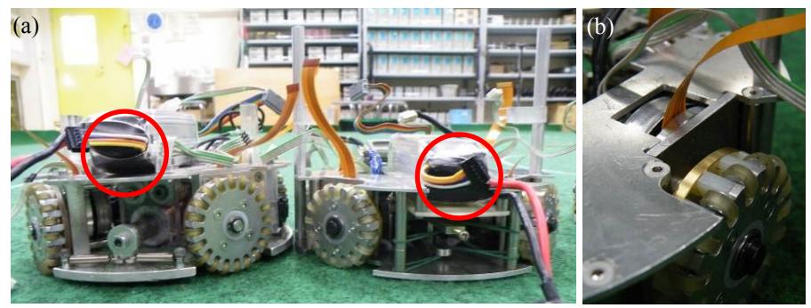 Fig. 10 (a) Lower height of new robot (right one; red circle shows the battery, left one is previous model) and (b) top of the motor for driving wheel.