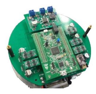 Fig. 2. Picture showing all boards: the kicker module at the top, the stamp module at the center, five motor modules at the sides and one communication module at the corner. Beneath all, the main board.