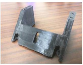 Fig. 2: Examples of 3D printed hardware we are experimenting with. (a) Dribbler Backstop (b) New Kicker Solenoid and Mid Plates