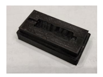 Fig. 1: (a) Mould box designed for liquid silicone molding (b) The latest dribbler grip for RoboCup 2020
