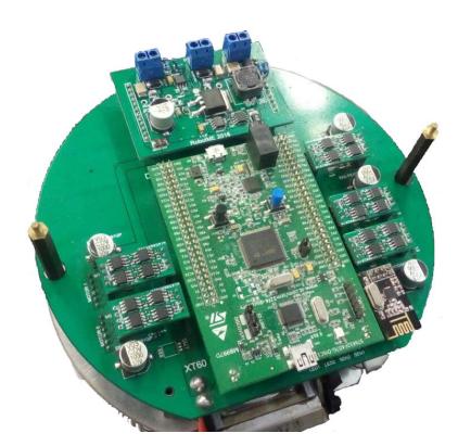 Fig. 6: Picture showing all boards: the kicker module at the top, the stamp module at the center, five motor modules at the sides and one communication module at the corner. Beneath all, the main board.