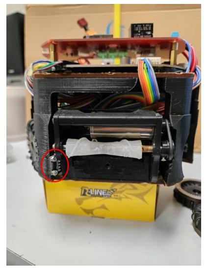 Fig. 4: Ball Proximity Sensor. (a) Front view, sensor in red circle. (b) Side view and closer to the sensor.