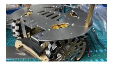 Fig. 1: Left: Render of the base plate with wheel arrangement and kicker (front right wheel and controller removed, exposing motor). Centre: Intermediate stage, plywood base plate. Right: completed, with PETG shell.