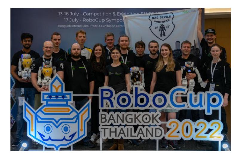 Fig. 1. The Nao Devils team members at RoboCup 2022. From left to right: Mrunal Hatwar, Arne Moos, Leon B., Dominik Brämer, Joël Haubold, Lisa Dasmann, Jonas Dauer, Mahdokht Mohammadi, Henri Gründer, Simon Koschel, Alexander Voß, Alicia Gayda, Thomas Klute, Aaron Larisch and Diana Kleingarn. (Missing: Steven Pieper, Ingmar Schwarz)