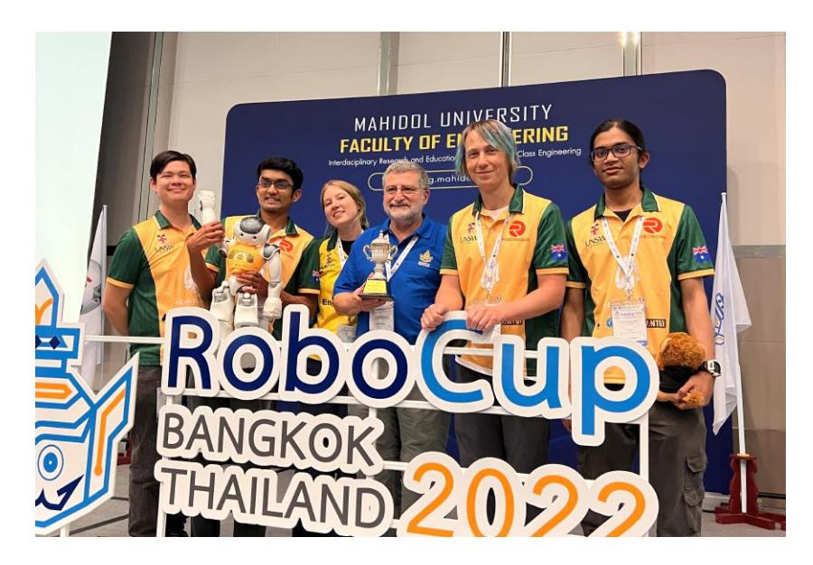 Fig. 1. The rUNSWift 2022 team members at RoboCup 2022 in Bangkok, Thailand. From left to right: Peter Schmidt, Abhishek Vijayan, Maria Lizura, Claude Sammut, Mikhail Asavkin, Neeraj Gopikrishnan