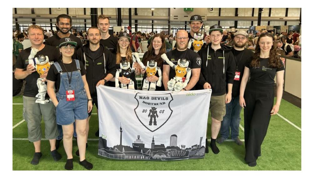 Fig. 1. The Nao Devils team members at RoboCup 2023. From left to right: Thomas Klute, Mrunal Hatwar, Mahdokht Mohammadi, Alexander Voß, Leon B., Alicia Gayda, Lisa Dasmann, Arne Moos, Aaron Larisch, Steven Pieper, Dominik Brämer, and Diana Kleingarn.